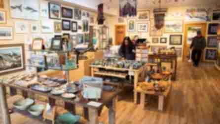 People shopping in an open gallery with artwork on walls and tables