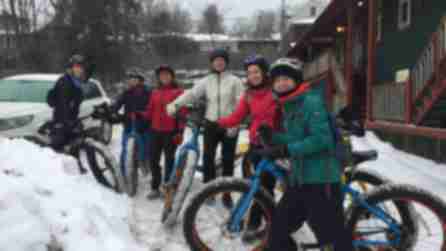 People in snow on bikes with High Peaks Cyclery/Mountain Adventure Center