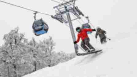 Two people ski down a slope near a chair lift at Belleayre Mountain