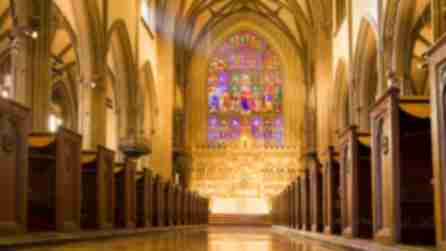 The interior pews and stained glass windows of Trinity Church in New York City