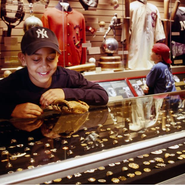 Kid in Yankees hat looking at display at National Baseball Hall of Fame